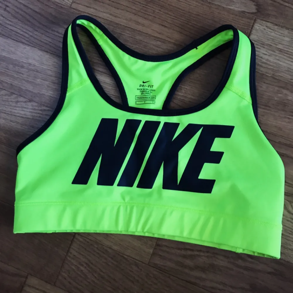 Jättefräsch limegrönfärgad neon sport-BH från Nike i nyskick. Köpt för något år sen men endast använd en gång. Passar för XS/S då den är en aning stretchig.    Ger ett bra stöd och sitter åt ordentligt. Nypris 299 så passa på. 😘 Använder Swish. . Toppar.