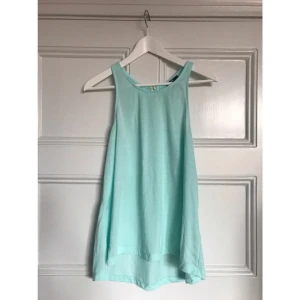  - Turkost A-linjeformad topp från H&M med dragkedja på ryggen. Köparen står för frakten och betalning sker via swish.