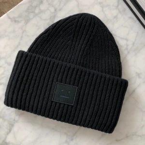 SÖKER!! - Söker svart äkta acne mössa! Till ett bra pris!