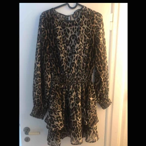  - Leopard klänning använd 1 gång. Storlek 38. Volang ner till.