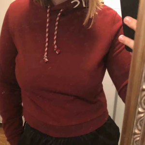 Hoodie  - Crop top i en fin vinröd färg med text på luvan (det står; RebelliousRebel) Den ser inte bra på mig eftersom att jag har växt ur den lite. 💕