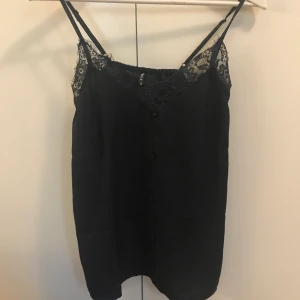 Glansigt oanvänt linne. Mörkblått XS - Knappar på framsidan som detaljer, också spetsdetaljer! 