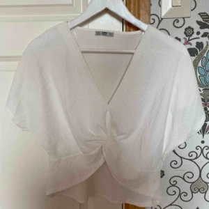  - Vit topp med twist vid magen. Helt oanvänd
