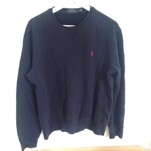  - Herrtröja från Ralph Lauren, storlek M. Marinblå med röd logga på bröstet.  Fint skick!