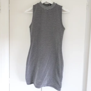  - Slimmad klänning med ränder och två knappar i nacken