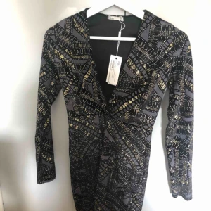  - Helt oanvänd klänning, vringad glittrig. 