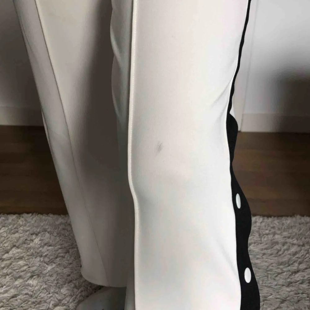 Vita stuprörsbyxor från junkyard med knappar+svart rand på sidan. En liten fläck som ej går bort på knät, kan möjligtvis gå ner i pris pga det. Supersnygga!  Frakt 50kr. Jeans & Byxor.