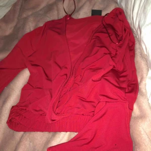  - Röd blus med resor längst ner, magtröja! Ganska djup v rigning men går att sätta ihop med en säkerhets skurk! Trumpet ärmar lite kortare, super snygg har lite mörkare färg i verkligheten