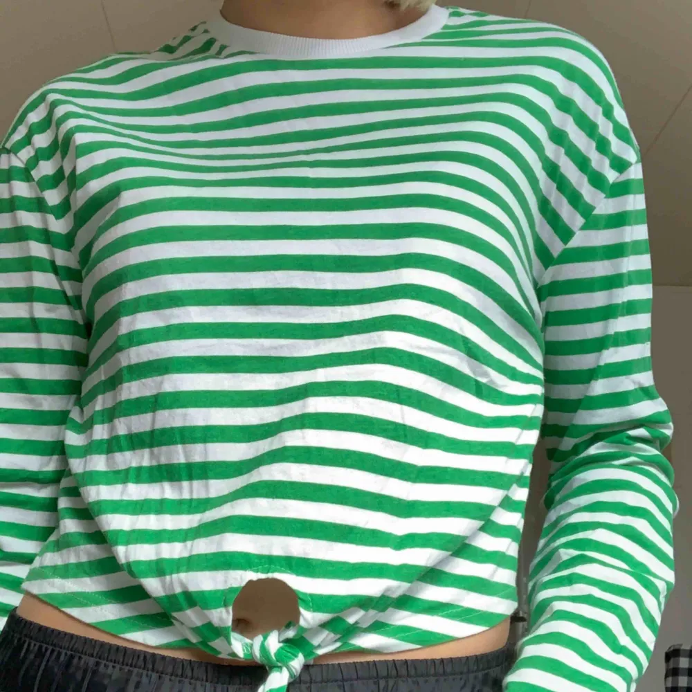 En grön randig långärmad t-shirt med vida ärmar, med ett litet gulligt hjärta på armen. Köpt i Danmark för 200kr. Toppar.