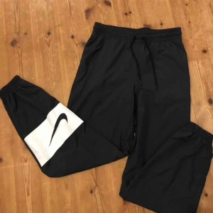  - Träningsbyxor/trackpants från Nike, loggan sitter bak på vaden och det är snörning med resorband i midjan! Köparen står för ev frakt