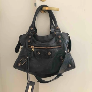  - Säljer min älskade Balenciaga City Bag i en mörkblå/melerad färg med gulddetaljer. Måste bli såld nu i veckan så pris kan diskuteras. 