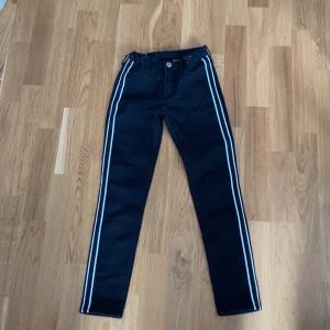 Ett par svarta jeans i storlek 134  - Två vita ränder och en svart rand ganska fint skick frakt 63kr 📦