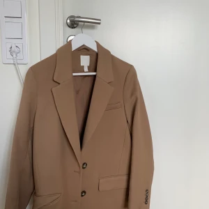 Beige kappa från hm - Jättefin beige kappa från hm som jag köpte i höstas men som tyvärr inte har kommit till användning så mycket. Jacka är i ny skick o frakten ingår i priset!