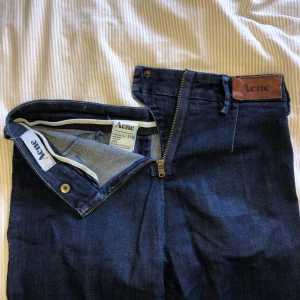 Acne jeans - Mörkblå Acnejeans med vintagelook. Dragkedja bak och inga fickor bak, endast fram, skitcoola! Använda men superbra skick och kvalité. Säljes pga för små för mig så väldigt liten i storleken (har annars 25/26) Pris kan diskuteras! Köparen står för frakt :)