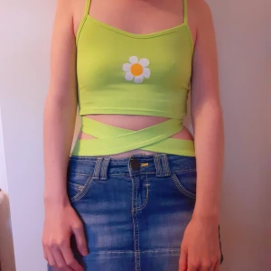 Flower Top - Ursöt grön unik knyttopp med blomma i mitten🌼Fått i present för längesedan men aldrig kommit till användning. Nyskick! Inget märke står inuti toppen. FRI FRAKT VID KÖP SENAST 4 JUNI