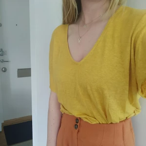 Gul linne t shirt - Gul t shirt I linne med knutar på ärmen. Sitter jätteskönt och luftigt! Sparsamt använd. Storlek S. Vi delar på frakten ✨