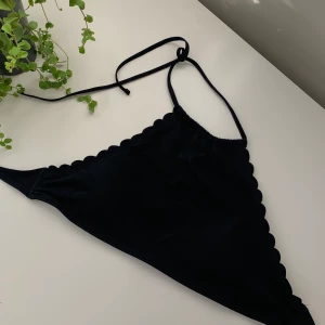 Svart bikini - Bikini med hög hals (inte polo), med detaljer på sidan. Justerbar då den har snören, aldrig använd, jätte fin nu till sommaren! Kan användas som topp också! Köparen står för frakten💕🦋