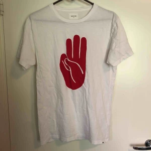  - En vit T-shirt med rött tryck från Wood Wood