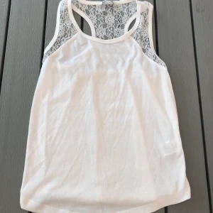 Linne i storlek 158,164 - Ett fint vitt linne med brottarrygg i spetts. Storleken är 158,164 ungefär som en XS/S. Har använt några fåtal gånger så den är i bra skick. (Frakten ingår i priset)