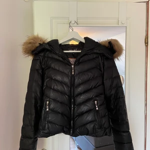Hollies - En snygg svart Hollies jacka i mycket gott skick. Storlek 36. Äkta päls på luvan!❤️ Köpt för 3500;-. 
