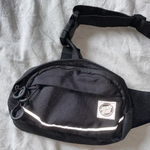 Santa Cruz waist pack - Väska/waist pack från Santa Cruz. Aldrig använd, nyskick. Reflexdetaljer, tre fack. Nypris ca 350kr säljer för 100 + frakt!
