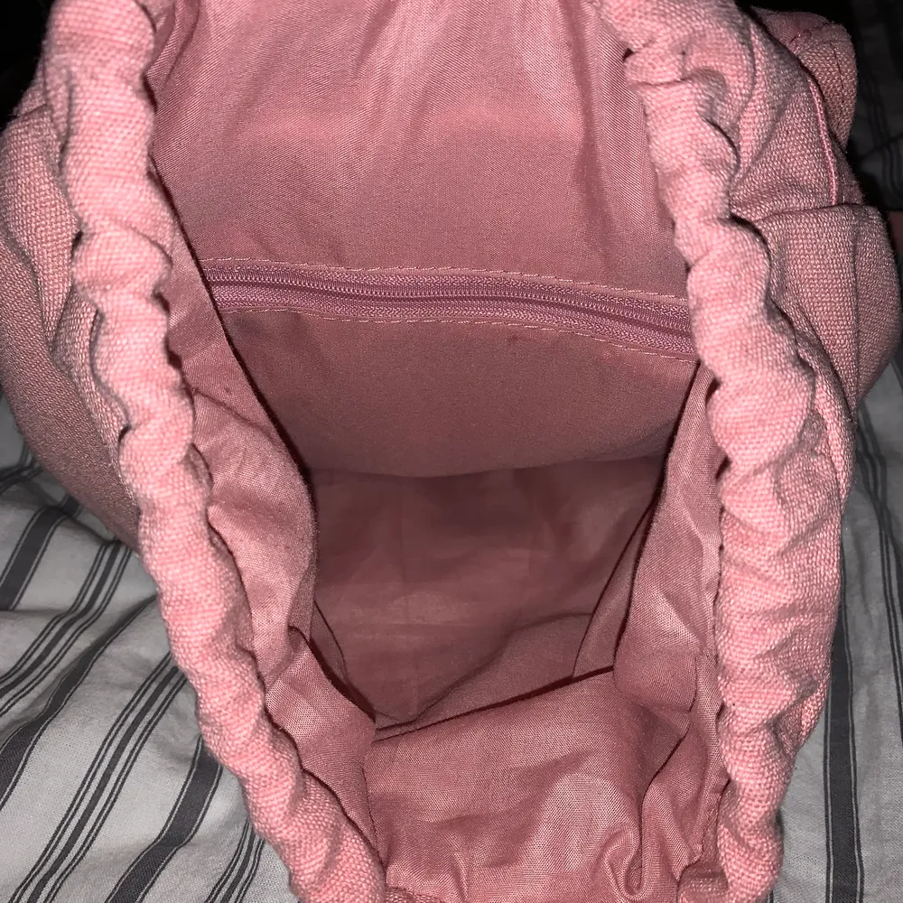 En rosa väska med ett ytter fack och ett inner fack det får plats mycket I den . Väskor.