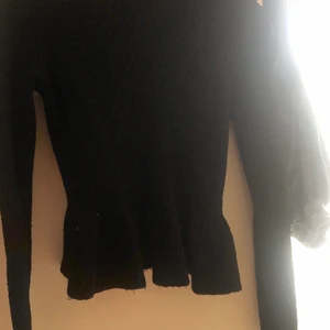 Söt svart tröja - Säljer denna oanvända svarta tröja med volanger som framhäver midjan
