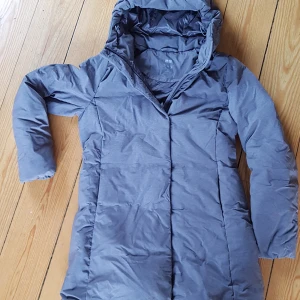 UNIQLO Kappa.  - Ultralätt, vindtät och klarar av lätt regn. Färgen luras lite se korrekt färg på bilden i mitten. Den är grå! Inköpt förra året och använd sparsamt. Bra skick och inga skavanker.