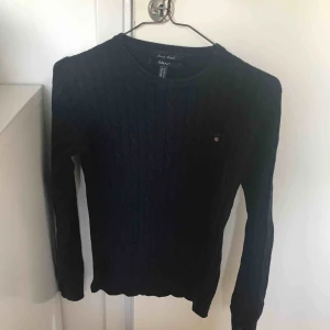  - GANT kabelstickad tröja. Använd fåtal gånger därav är den i fint skick. Mörk marinblå i färgen. 