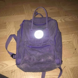  - lila kånken-väska. lite sliten, har använts i många år! fortfarande superfin och inga hål. finns i värnamo eller skickas mot att köparen betalar frakt. den är i standardstorleken, superbekväm och fin!! köptes för 600