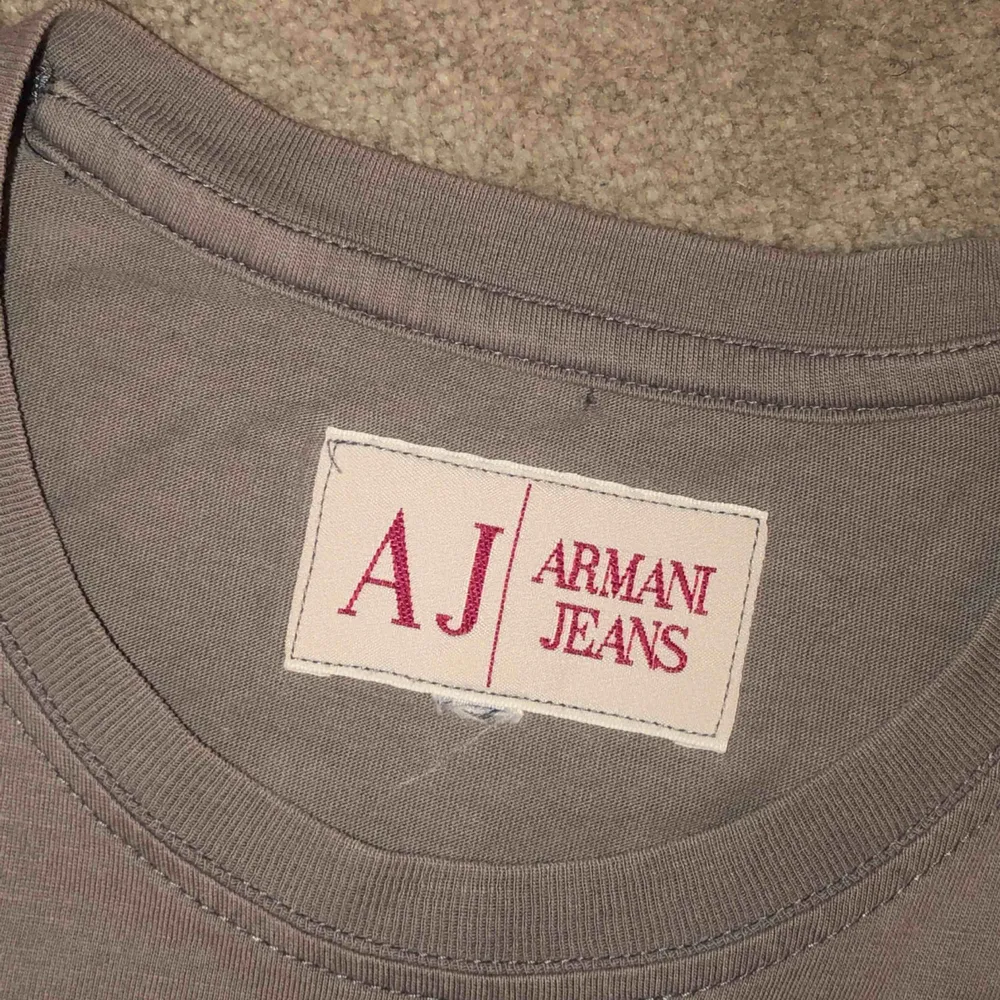 Grå Armani Jeans vintage tröja. Köpt på Humana för typ 100kr. Super i skick. Storlek är oklar men jag skulle säga att den passar S till M.  Kan mötas upp eller posta! Pris kan diskuteras!. T-shirts.