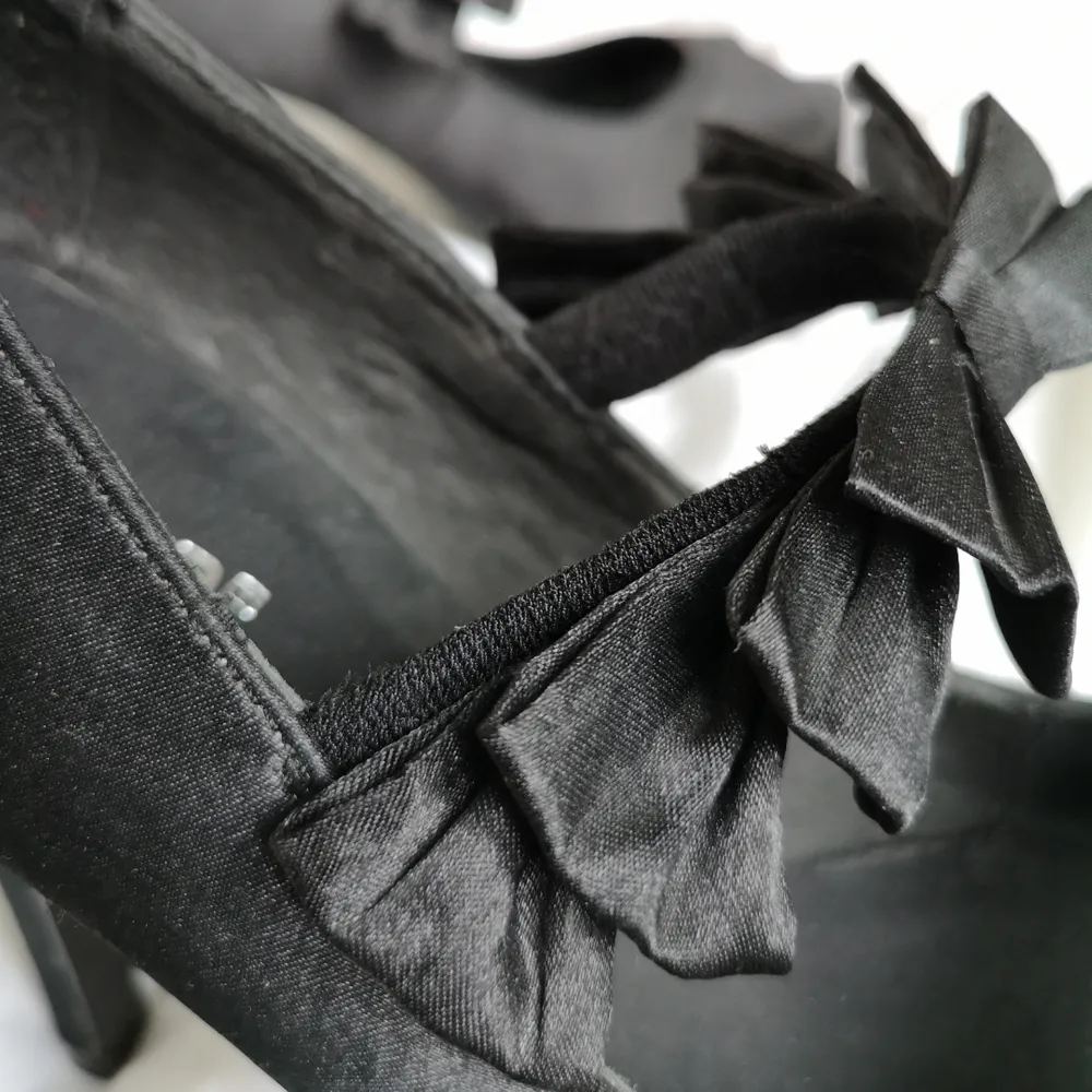 Knappt använda high heels i siden med platå framtill. Klacken är som ny. Dekorativa rosetter framtill som håller foten på plats. Passar strl 38-39.. Skor.