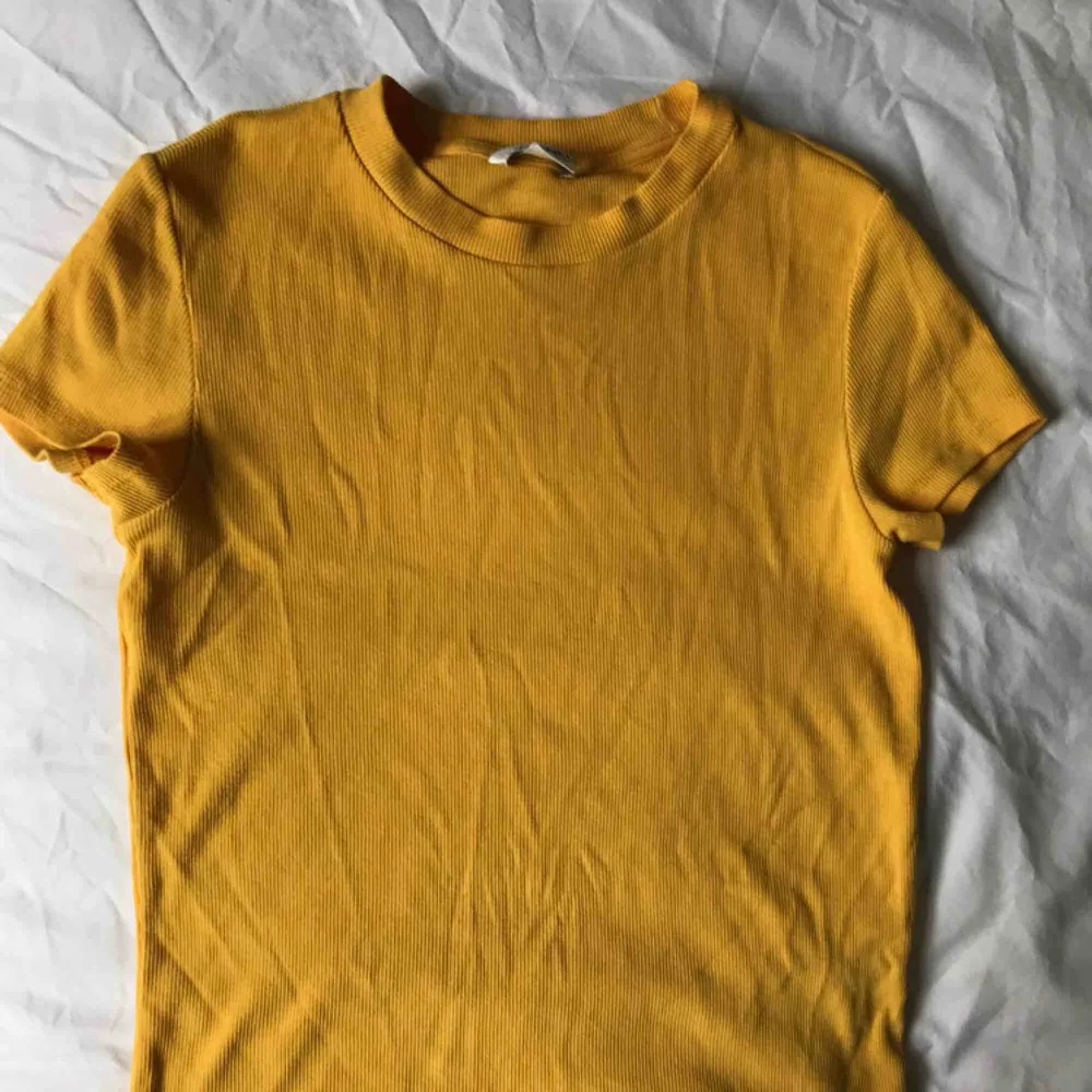 Gul ribbad t-shirt från Monki i S. Den är nästan aldrig använd och har en väldigt snygg passform! Swish och frakten ingår inte.. T-shirts.