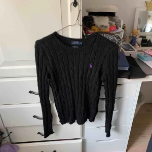 Kabelstickad tröja - Kabelstickad svart Ralph lauren tröja med lila logotyp. Nyskick:)
