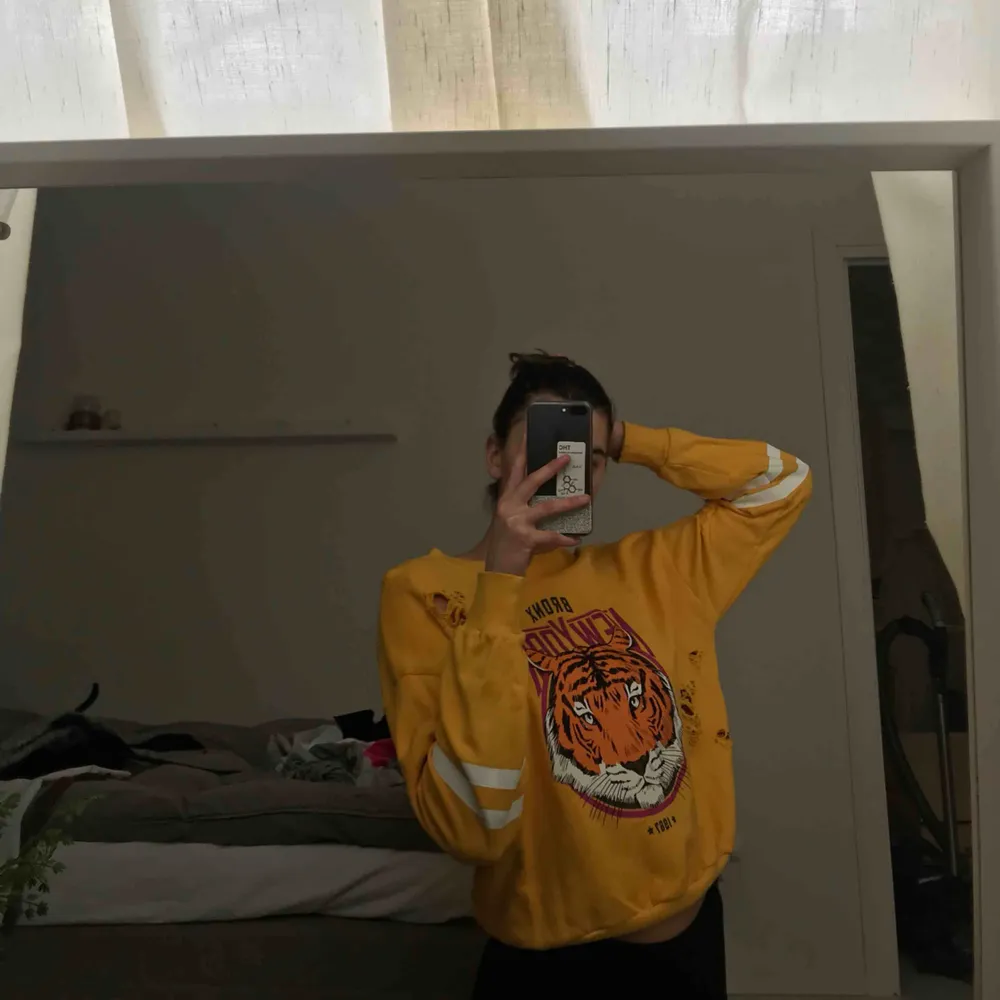 Gul sweatshirt med ett lejon på. Tröjor & Koftor.