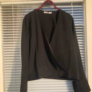  - Oanvänd omlottblus säljes. Strl: 38, men upplevs som en One Size