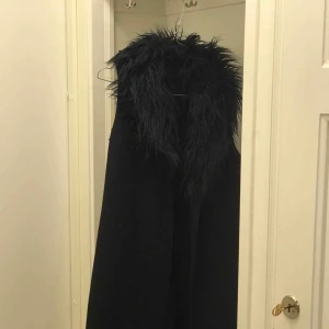  - Filippa k väst/kappa, går till knäna på mig som är 160 cm lång.  Snyggt att ha en skinnjacka under och denna över. 