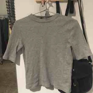  - Knappt använd ljusgrå halvpolo med ribbstickning. Så fin till ett par jeans eller instoppade i vilka byxor som helst! Stretchig och mjuk.  Strl 40 men är ganska liten i storlek så passar även en 38.