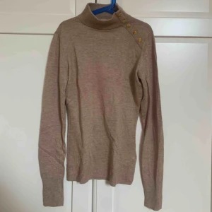  - Tajt långärmad tröja med hög krage och låssas knappar i guld på vänster sida vid användning. Använt 3 gånger max.✨