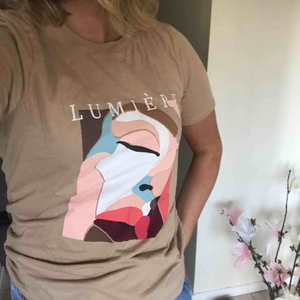  - Beige t-shirt med tryck. Aldrig använd! Ni står för frakten  