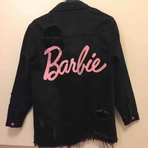  - Oversized jeansjacka från Missguideds kollektion med Barbie. Silvriga knappar och cutots/revor på bland annat axeln. Är storlek XS och endast använd ett fåtal gånger.