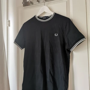 FRED PERRY T-SHIRT - Köpt i Berlin förra sommaren. Knappt använd, bra kvalité och fortfarande i fräscht skick. Dock ett litet hål på magen, syns knappt. Nypris 550kr säljer för 150kr 