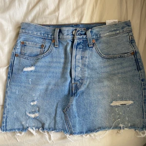 Jeanskjol från Levis  - Jeanskjol från Levis i superfint skick. Köpt förra sommarn men användes knappt pga köpte den förliten. Passar till nästan precis allting på sommaren. Både till bikini på stranden och med en stickad tröja på kvällen. Nypris 500