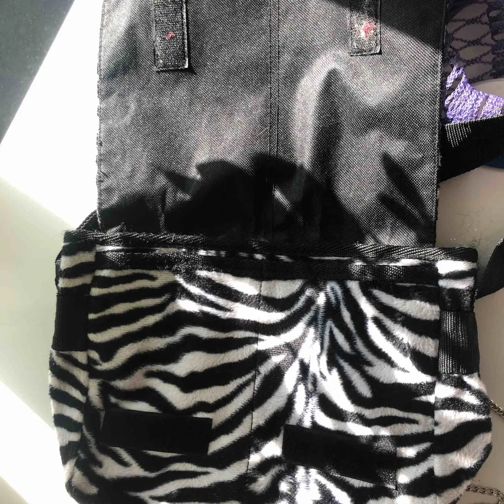 Liten axelremsväska i zebra-mönster. Väskor.