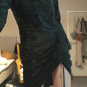 Snygg nyårsklänning i sammet - Skit snygg mörkgrön klänning i sammet, perfekt till nyår eller jul! Dragsko nertill vid benet. Nyskick!