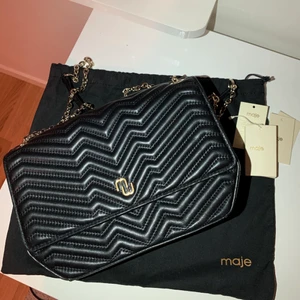 Maje väska - Jättefin väska från maje! Inköpt på nk i somras, dustbag medföljer. Finns även kvitto💕 jättebra skick ser nästan helt ny ut, kedjan kan man ha både crossbody och dubbelt över axeln. Nypris ca 3000kr🥰skriv för mer info