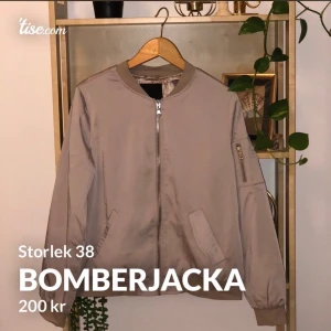 Bomberjacket EU38 - Beige bomberjacka i glansigt tunnare material. Oanvänd. Storlek 38.