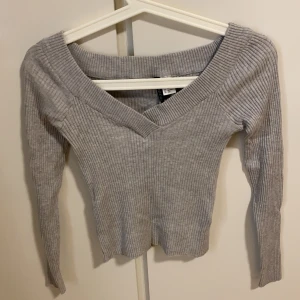 Ljusgrå stickad tröja  - Tunn, mysig material på en ljusgrå tröja med V form på framsidan 