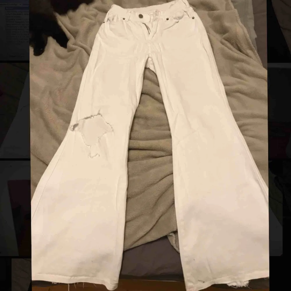 Fina vita flare jeans, klippt hål i ena knät, kan mötas upp i sthlm annars står köparen för frakten, lite smutsigt på bak sidan där nere men går å tvätta bort . Jeans & Byxor.
