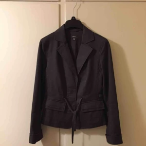  - Grå snygg figursydd kavaj med skärp i midjan som går at spänna/dra åt el ha löst. Ärm går att ha uppkavlad enligt foto alternativt ta ned. Se snygga fickor också.:-)